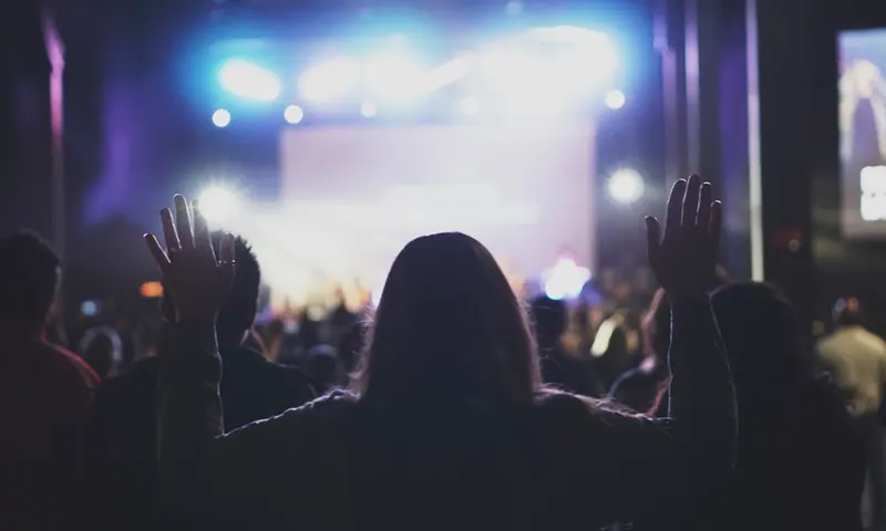 Congregación con las manos en alto durante un culto